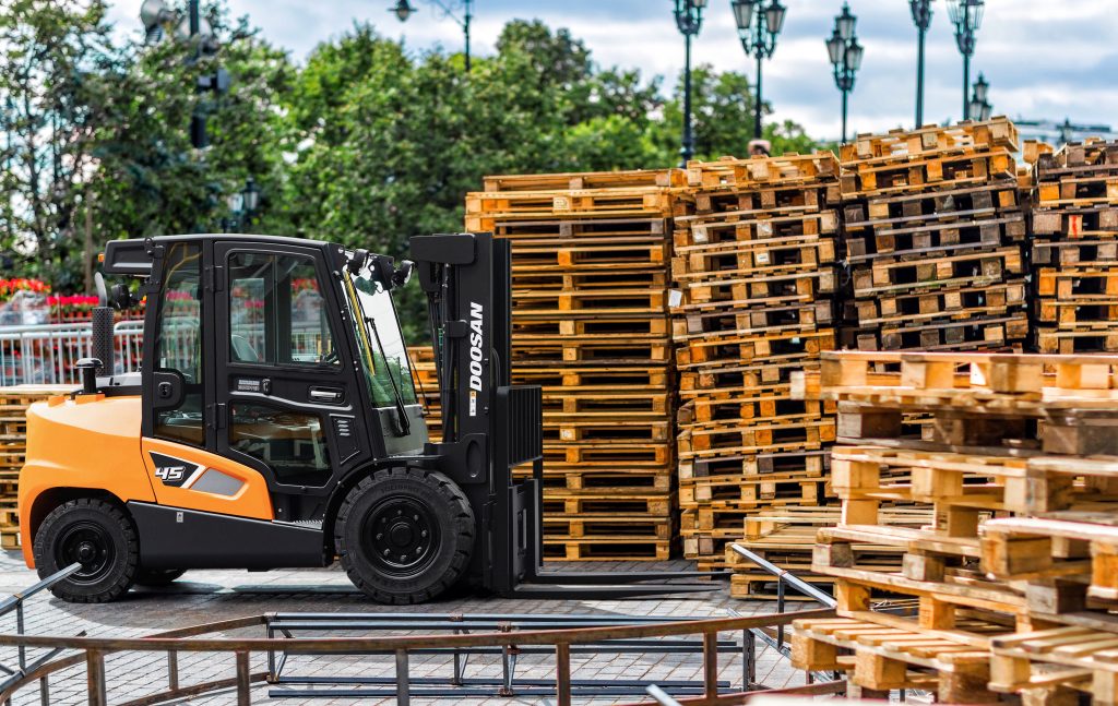 Forklift By Wooden Objects Against Trees Doosan Forklifts UK